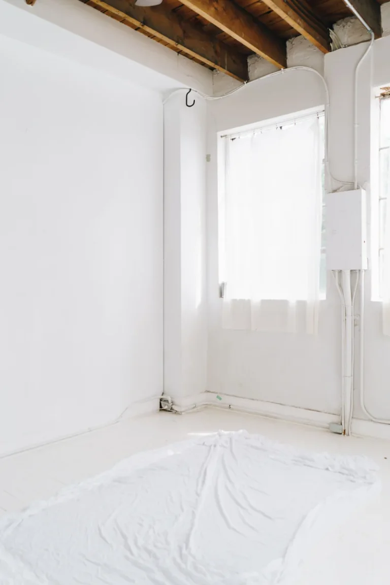 Pièce en rénovation avec murs blancs, enduits lisses et sol protégé